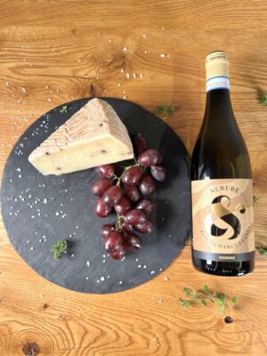 Eine klassische Kombination aus köstlichem Käse auf einem Teller mit Flügelnüssen, neben einer Flasche exzellenten Weins