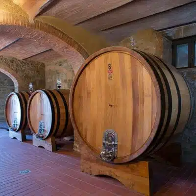 Das Bild zeigt große Eichenfässer, in denen der Brunello di Montalcino reift.