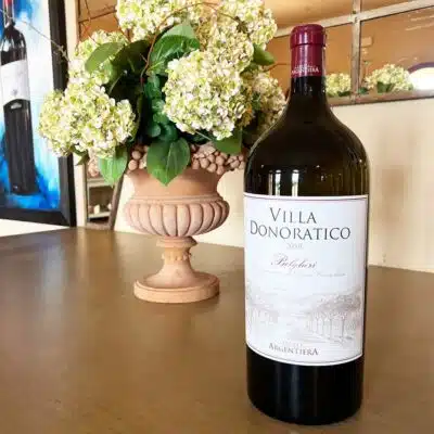 Das Foto zeigt Flasche rotwein "Argentiera " von Tenuta Argentiera mit Frische Blumen.